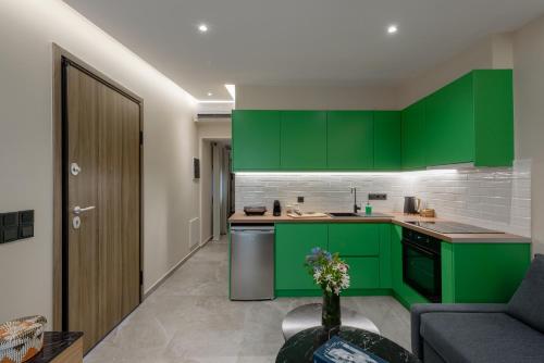 a kitchen with green cabinets and a couch at Galio Suites Airport by Airstay in Spata