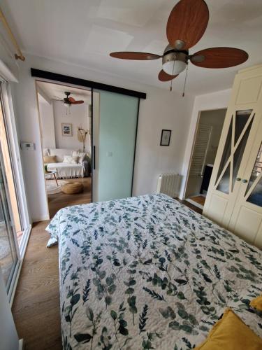 um quarto com uma cama e uma ventoinha de tecto em Cozy Rustic Home em La Pobla de Farnals