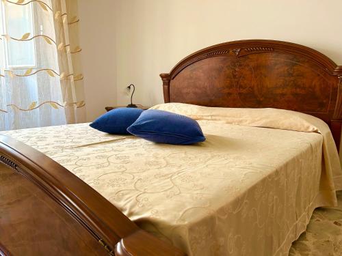Una cama con dos almohadas azules encima. en Appartamento - Morciano Di Leuca, en Morciano di Leuca