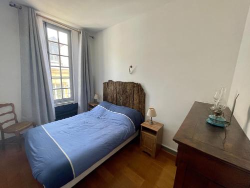 Schlafzimmer mit einem Bett, einem Schreibtisch und einem Fenster in der Unterkunft Appartement de Caractère au Cœur de la Cité Médiévale in Sarlat-la-Canéda