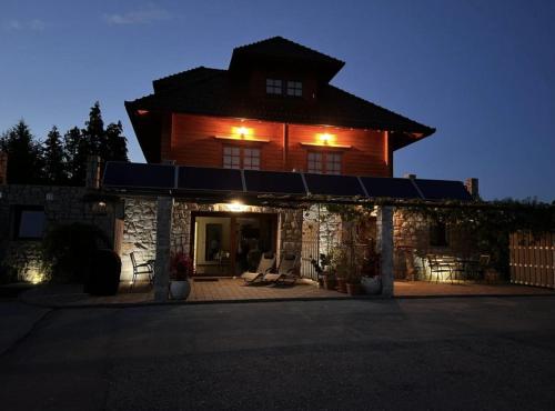 a large wooden house with a porch in front of it at Spacious apartment in nature with sauna! in Postojna