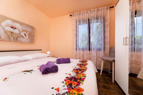a bedroom with a bed with flowers on it at Apartman "ELA" in Njivice