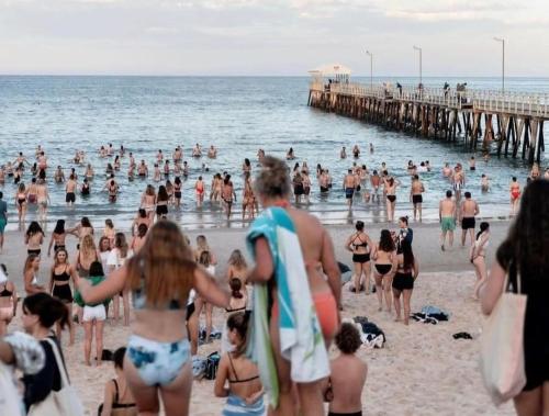 a crowd of people on a beach with a pier at The Sea Haven 200m to Henley Beach in Henley Beach