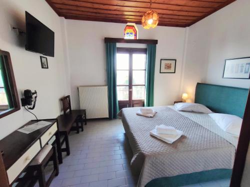 a hotel room with two beds and a television at Hotel Vrionis in Agios Dimitrios