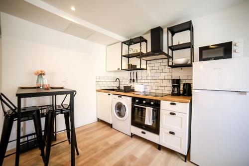 a kitchen with a white refrigerator and a table at Studio cosy équipé, Centre ville in Orange
