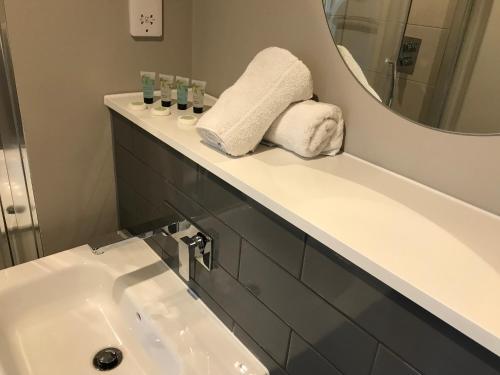 een badkamer met een wastafel en een spiegel bij Quality City Birmingham in Birmingham