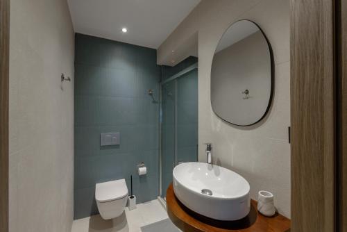 a bathroom with a sink and a toilet and a mirror at Galio Suites Airport by Airstay in Spáta