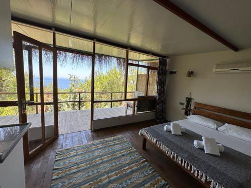 a bedroom with two beds and a view of the ocean at Honey Hill Faralya Forest Cabins by the Sea in Faralya