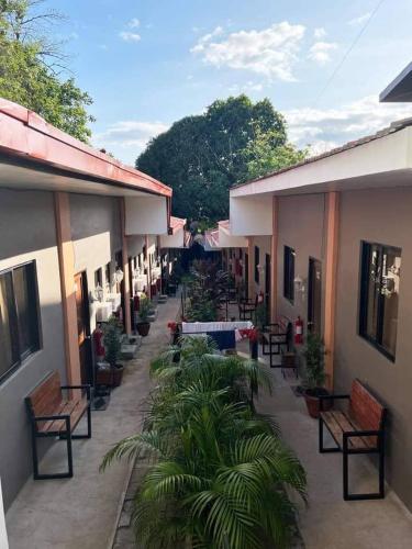 a courtyard of a building with benches and plants at CEBUANA'S TRAVELERS INN Coron in Coron