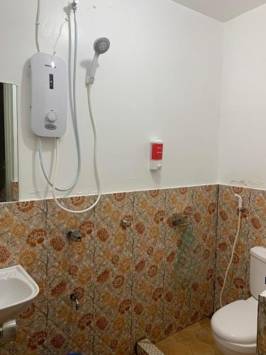 CEBUANA'S TRAVELERS INN Coron في كورون: حمام مع دش ومرحاض ومغسلة