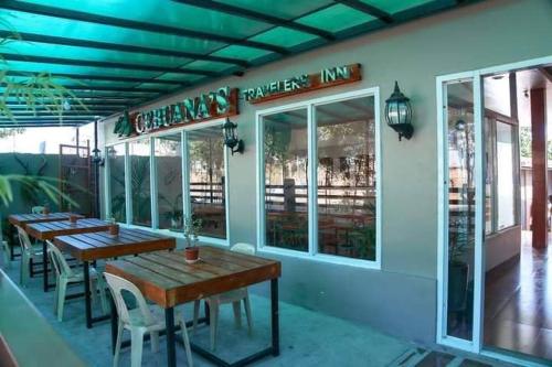 CEBUANA'S TRAVELERS INN Coron في كورون: مطعم بطاولات وكراسي خارجه