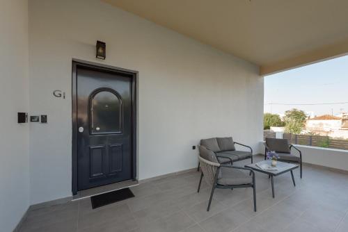 a room with a black door and chairs and a table at Galio Suites Airport by Airstay in Spáta