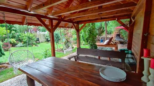 a wooden bench sitting under a wooden pergola at Apartament Pod Czereśnią in Suwałki
