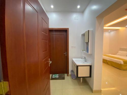 a bathroom with a door and a sink and a bed at Lona Park in Taif