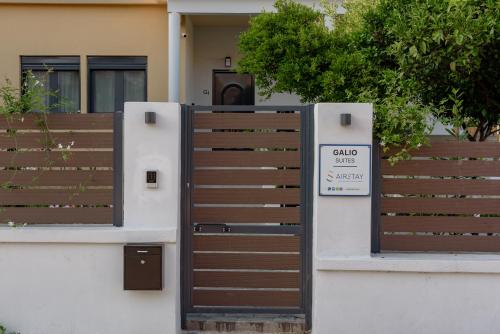 a gate with a sign on it in front of a house at Galio Suites Airport by Airstay in Spáta