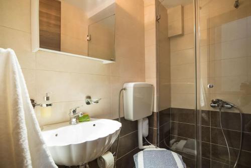 a bathroom with a sink and a shower at Modern, Stylish Maisonette in Itea