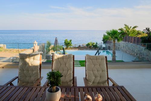 un patio con 2 sillas y vistas al océano en Villa Grand Blue, en Ierápetra