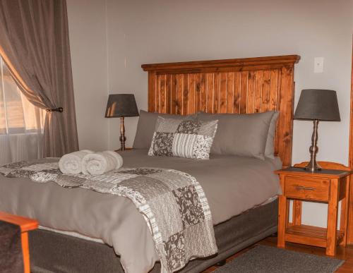 1 dormitorio con 1 cama con cabecero de madera en Donsveertjie Gasteplaas & Venue, en Heilbron