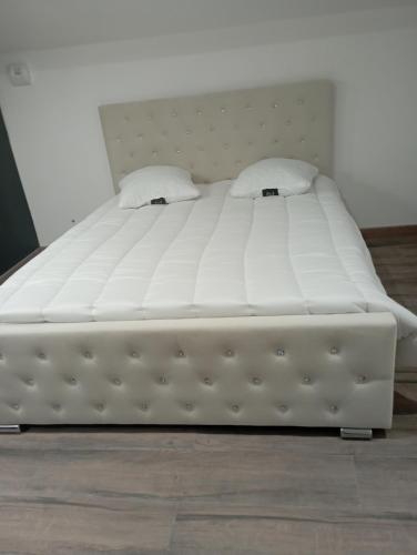 ein weißes Bett mit zwei Kissen darüber in der Unterkunft Villa Familliale 220 m2, Piscine ,Spa ,Plage,Clim,Wifi in Valras-Plage