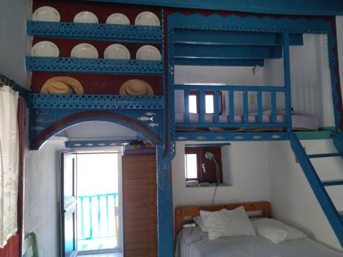 two bunk beds in a room with a bed and a window at KARAI in Astypalaia Town