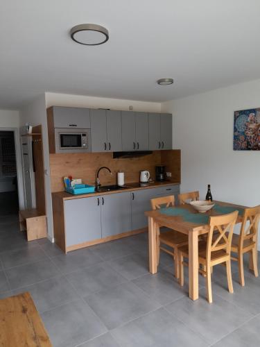eine Küche mit einem Tisch und Stühlen sowie eine Küche mit einem Waschbecken in der Unterkunft Milo Mare Apartaments in Mielno