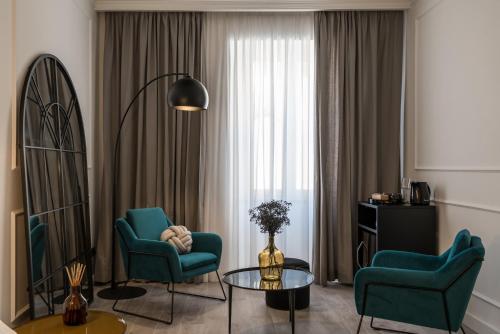een woonkamer met 2 stoelen, een tafel en een raam bij EC Luxury Rooms in Riomaggiore