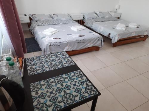 a room with two beds and a bench in it at Pensiunea Transilvania in Odorheiu Secuiesc