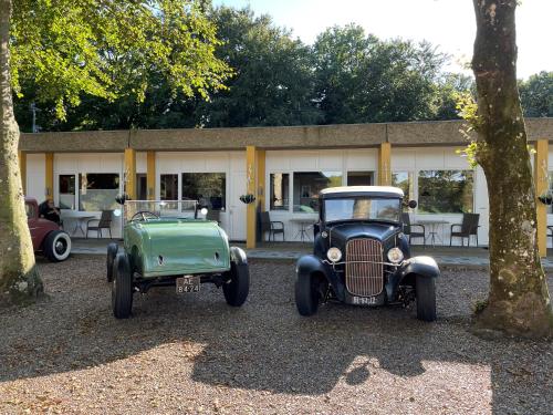 two old cars parked in front of a building at Motel Rovli in Skærbæk