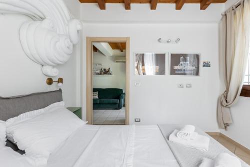 ein weißes Schlafzimmer mit einem Bett und ein Wohnzimmer in der Unterkunft Osvaldo - parcheggio e giardino privato in San Giovanni in Persiceto