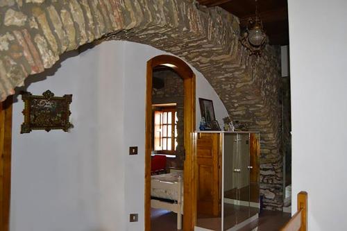 a room with a stone wall and an archway at Cilento Stone House in San Mauro Cilento