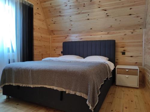 a bedroom with a bed with a wooden wall at 7Sense Nature Resort in Sapanca