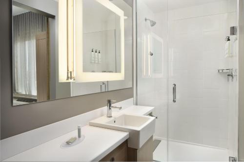 ein weißes Badezimmer mit 2 Waschbecken und einem Spiegel in der Unterkunft SpringHill Suites by Marriott Jacksonville Baymeadows in Jacksonville