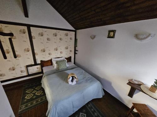 Un dormitorio con una cama con un perro. en Complex Valea Argesului, en Albestii de Arges