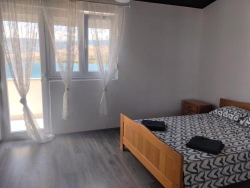 a bedroom with a bed and a large window at Pag Sea Mare in Pag