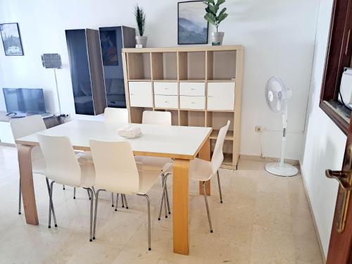 una sala da pranzo con tavolo bianco e sedie bianche di Beatiful and full-equipped flat in the city center a Ceuta
