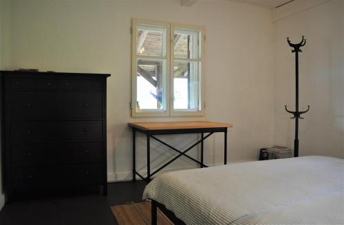 a bedroom with a bed and a dresser and a window at Chata nad Dziką Orlicą z jacuzzi in Poniatów