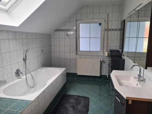 a bathroom with a tub and a sink at Ferienwohnung Familie Wieser in Liebenfels