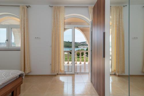 1 dormitorio con una puerta que da a un balcón en A3 - seafront apt with balcony 1 min to beach en Trogir