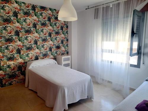 una camera con due letti e carta da parati floreale di Beatiful and full-equipped flat in the city center a Ceuta