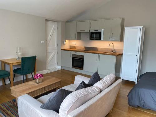 a living room with a couch and a kitchen at 2 person studio flat near Richmond Park in Strawberry Hill