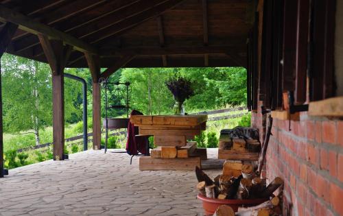 a pavilion with a wooden table and wooden logs at Chata nad Dziką Orlicą z jacuzzi in Poniatów
