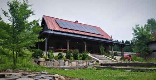 a house with a roof with solar panels on it at Chata nad Dziką Orlicą z jacuzzi in Poniatów