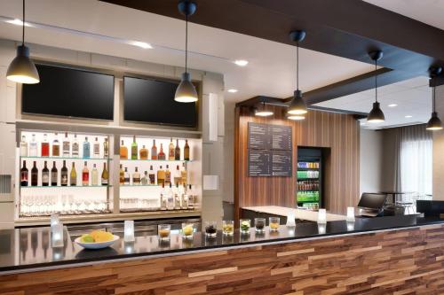 a bar with a lot of bottles of alcohol at Courtyard by Marriott Atlanta Duluth Downtown in Duluth