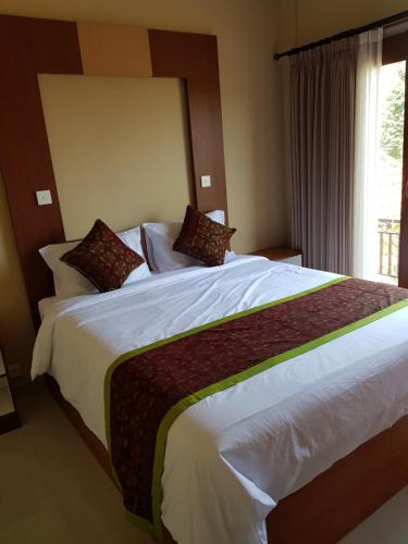 1 dormitorio con 1 cama blanca grande y ventana en Villager's House Ubud en Gianyar