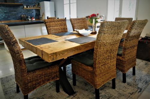 a wooden table with wicker chairs in a kitchen at Chata nad Dziką Orlicą z jacuzzi in Poniatów