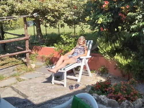 a woman sitting in a chair in a yard at ANITA B&B in Uscio