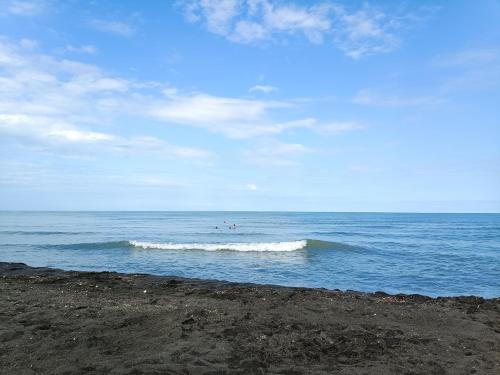 a group of people riding waves in the ocean at Crimson Serenity Appartment in Ureki