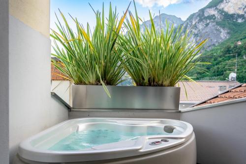 a bathroom with a toilet with plants in a window at Charming Loft - Private Hot Tub & Free Parking in Riva del Garda