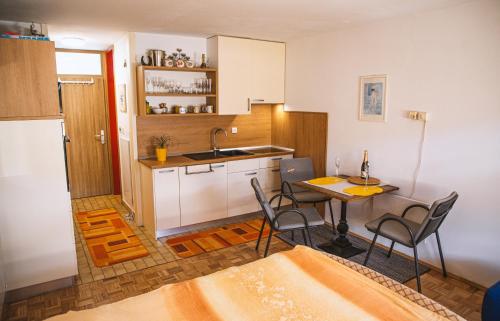 cocina con mesa, sillas y fregadero en Sončni apartma, en Bovec