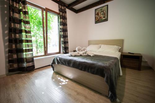 een slaapkamer met een bed en een groot raam bij Casa Arcadia Buzau Monteoru in Buzau